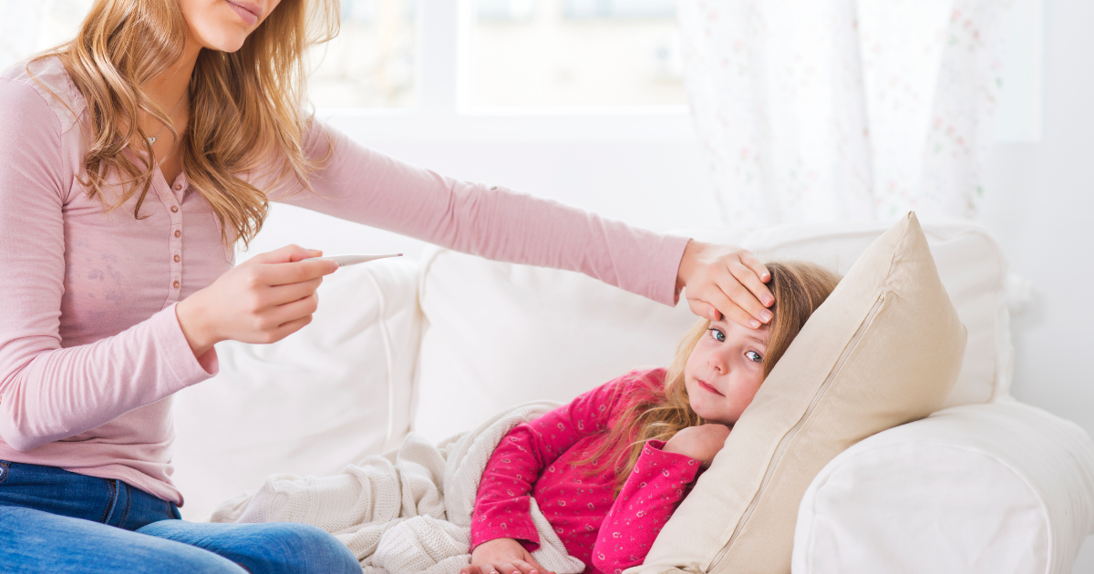 Mother checking daughter's temperature at home, unaware of asymptomatic contagion risks.